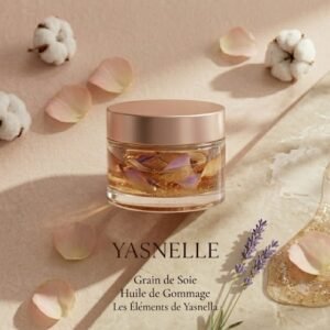 Pot en verre premium de l' Huile de Gommage "Grain de Soie" Yasnella, révélant une texture huileuse dorée infusée de pétales, à côté d'un échantillon de gel exfoliant sur un socle en marbre beige avec des fleurs de coton.